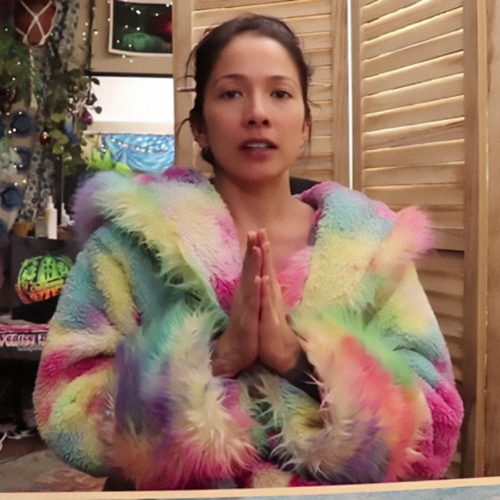 Person wearing a colorful fur coat with hands together, amid BookTube crisis discussion. Person wearing a colorful fur coat with hands together, amid BookTube crisis discussion.