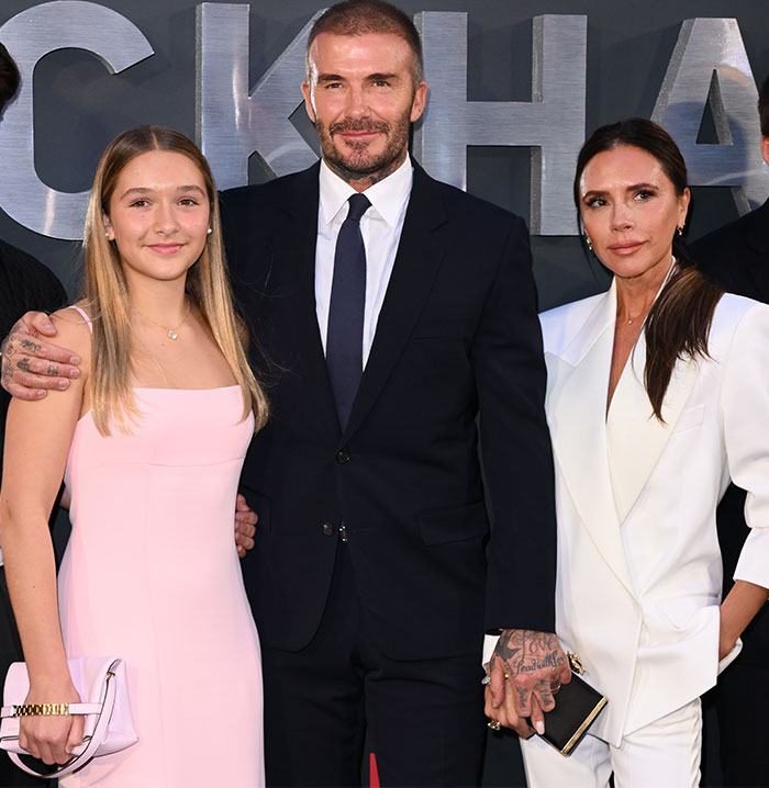 David Beckham with daughter Harper in a pink dress and family at an event. David Beckham with daughter Harper in a pink dress and family at an event.