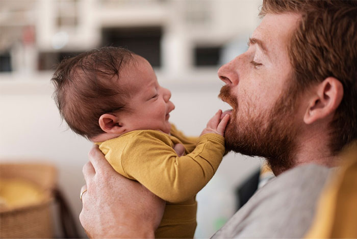 Father holding infant son, highlighting family dynamics and parental responsibility. Father holding infant son, highlighting family dynamics and parental responsibility.