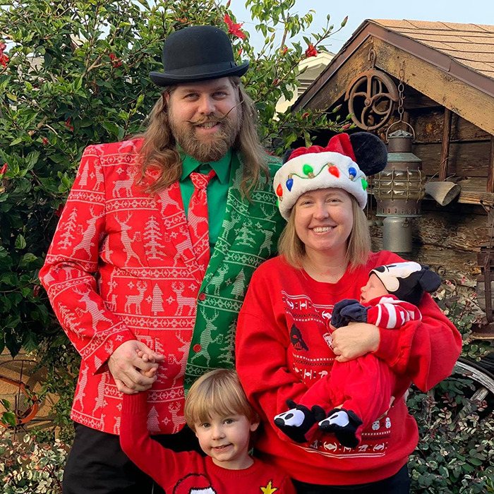 Matthew Van Andel in festive attire with family, including colorful holiday sweaters and hats, posing outdoors with Disney-themed decorations. Matthew Van Andel in festive attire with family, including colorful holiday sweaters and hats, posing outdoors with Disney-themed decorations.