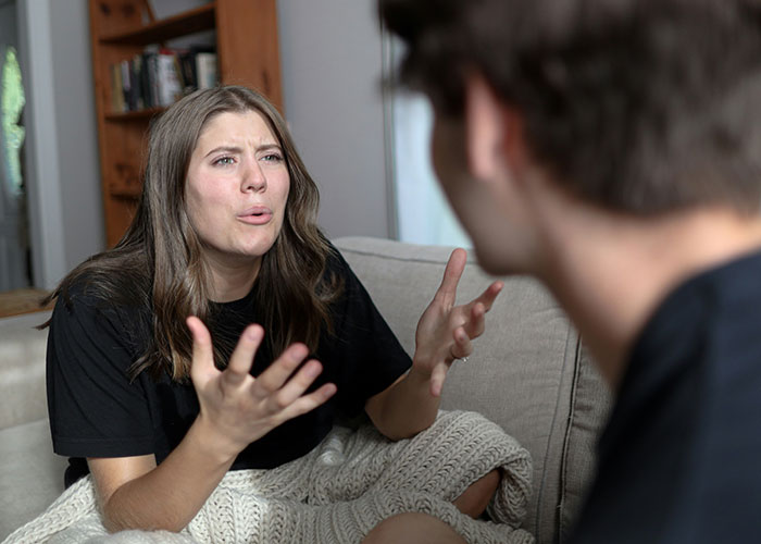 Woman frustrated during conversation on a sofa, discussing a job probation issue. Woman frustrated during conversation on a sofa, discussing a job probation issue.