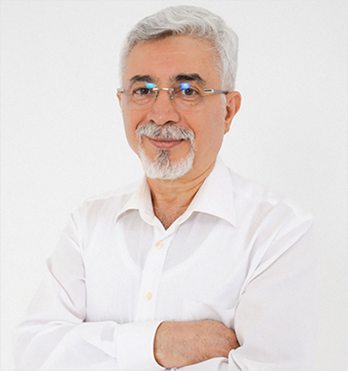 Man smiling with arms crossed, wearing glasses and a white shirt, related to Bianca Censori's plastic surgery makeover topic. Man smiling with arms crossed, wearing glasses and a white shirt, related to Bianca Censori's plastic surgery makeover topic.