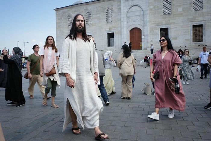 Street scene with diverse people in front of a historical building, capturing a unique perspective.