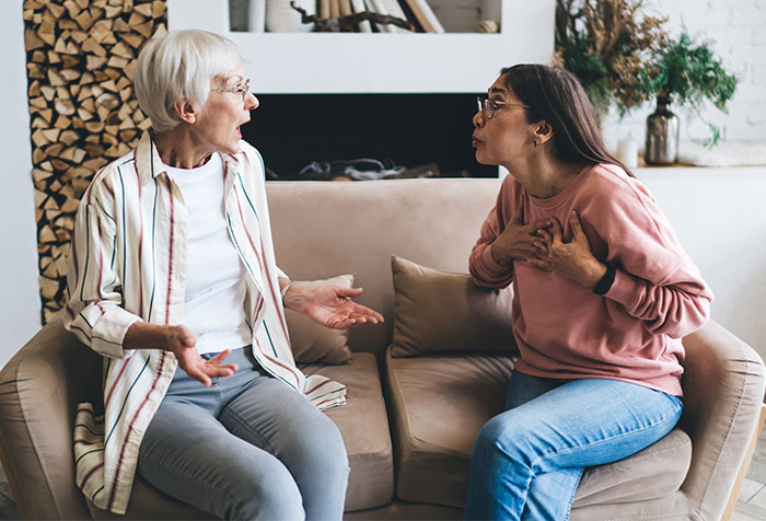 Two women argue intensely in a living room, highlighting a conflict with a difficult MIL. Two women argue intensely in a living room, highlighting a conflict with a difficult MIL.