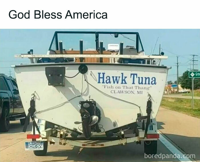 Boat trailer with "Hawk Tuna" sign on the road, reflecting men's humor.