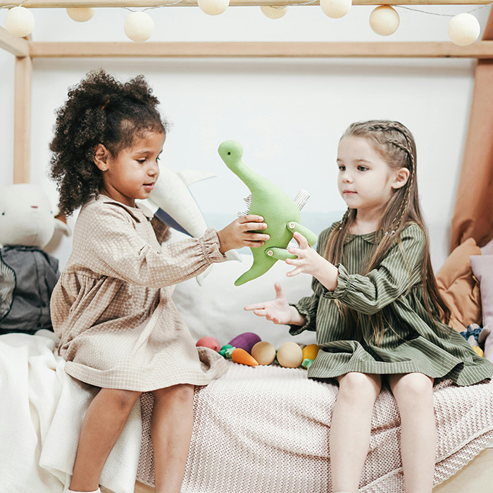 Two children play with a green dinosaur toy as it stirs up controversy online. Two children play with a green dinosaur toy as it stirs up controversy online.