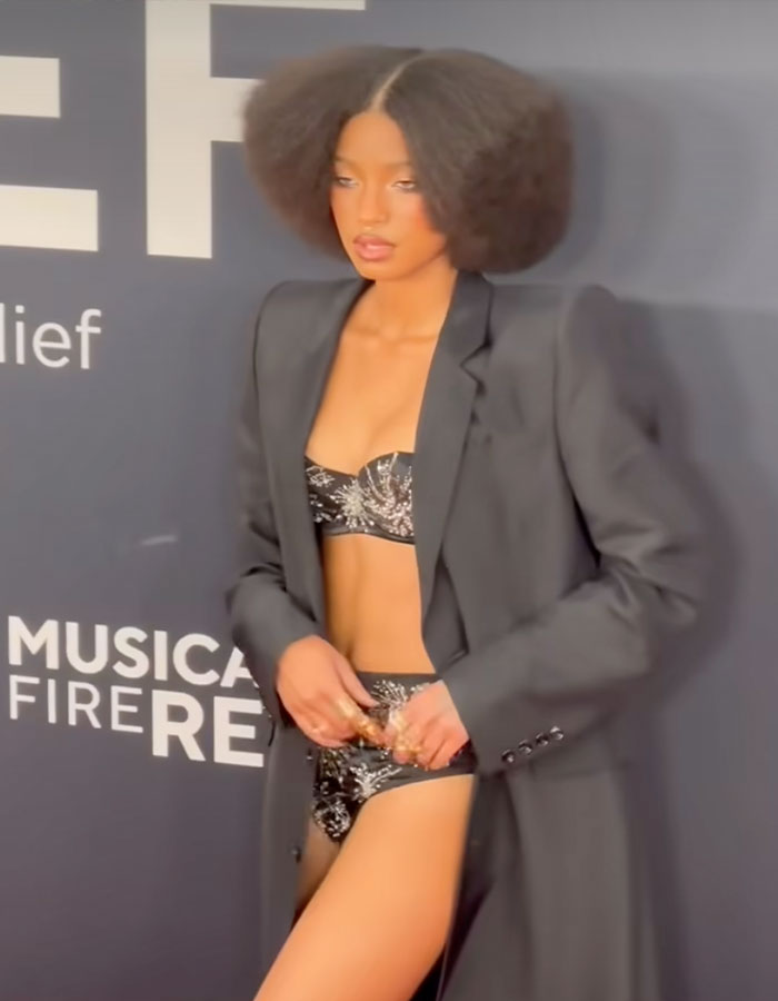 Young woman in a bold outfit with a black blazer and printed lingerie at the Grammys 2025. Young woman in a bold outfit with a black blazer and printed lingerie at the Grammys 2025.