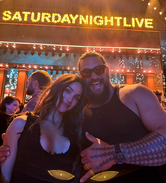 Jason Momoa at Saturday Night Live event with his new girlfriend, posing with a smile under marquee lights. Jason Momoa at Saturday Night Live event with his new girlfriend, posing with a smile under marquee lights.