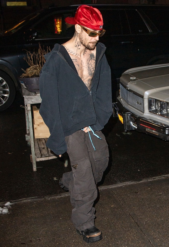 Man in a red cap and sunglasses walking on a street in casual clothes, looking down. Man in a red cap and sunglasses walking on a street in casual clothes, looking down.