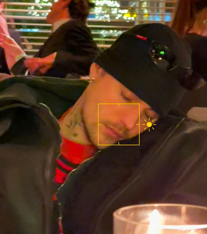 Young man wearing a black beanie and jacket, appears tired, resting his head in a dimly lit Brooklyn restaurant. Young man wearing a black beanie and jacket, appears tired, resting his head in a dimly lit Brooklyn restaurant.