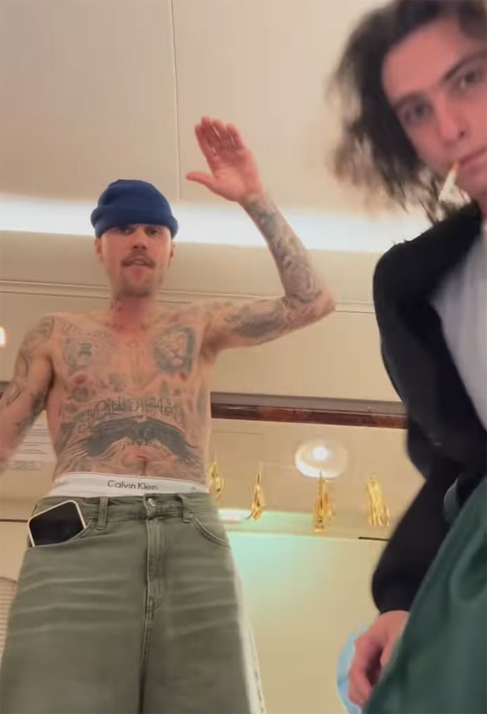 Tattooed man in green pants and beanie stands with a blurred background, emphasizing "new daddy" concerns. Tattooed man in green pants and beanie stands with a blurred background, emphasizing "new daddy" concerns.