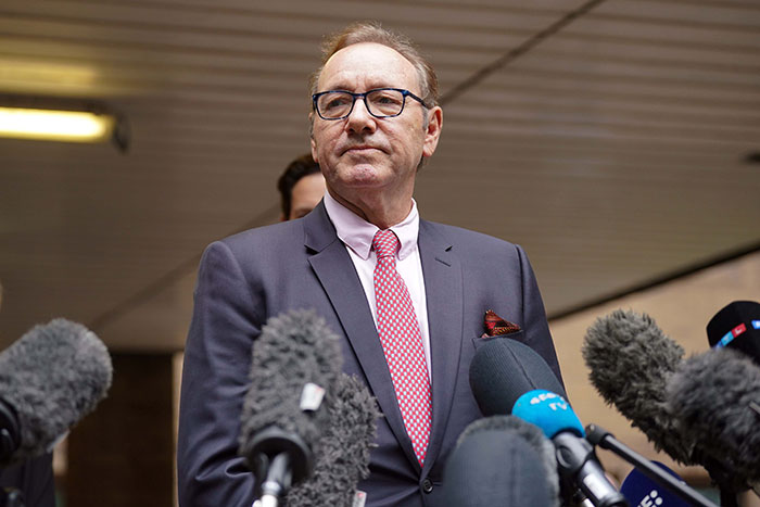 Kevin Spacey in a suit speaking to press, surrounded by microphones, related to Kevin Spacey claims. Kevin Spacey in a suit speaking to press, surrounded by microphones, related to Kevin Spacey claims.