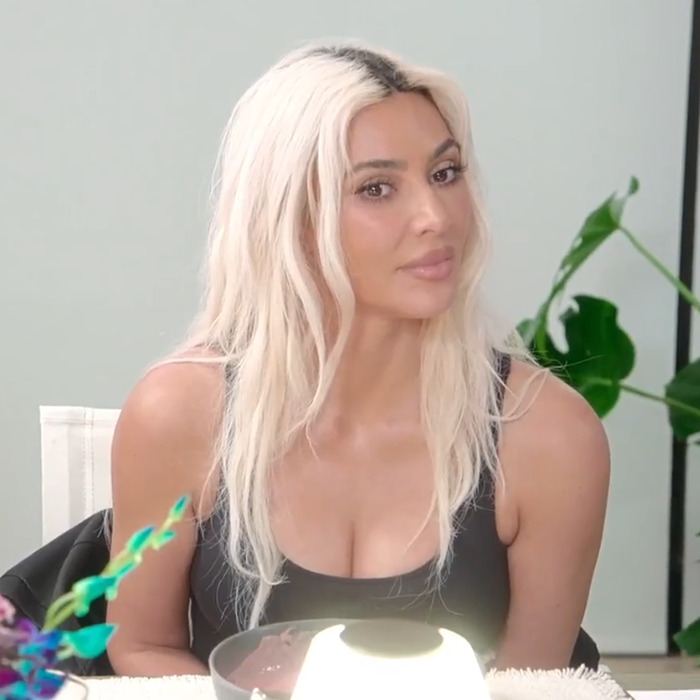 Kim Kardashian sitting at a table, surrounded by plants, during a dinner discussion. Kim Kardashian sitting at a table, surrounded by plants, during a dinner discussion.