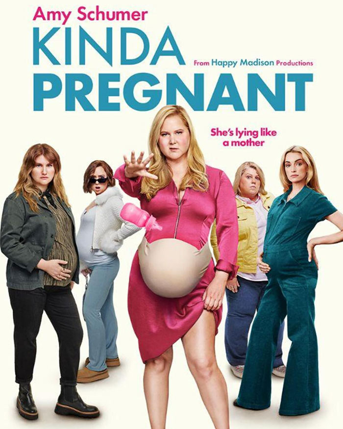 Amy Schumer in a comedic pose for "Kinda Pregnant" with a humorous group of characters and exaggerated baby bump. Amy Schumer in a comedic pose for "Kinda Pregnant" with a humorous group of characters and exaggerated baby bump.