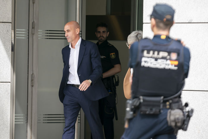 Former football head leaving a building, surrounded by police officers, after being fined €10,000. Former football head leaving a building, surrounded by police officers, after being fined €10,000.
