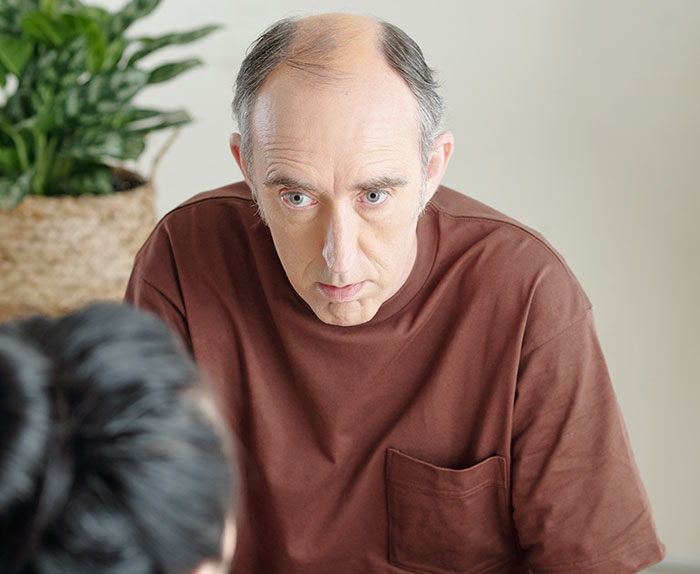 Man in brown shirt appears concerned, discussing issues related to stepdaughter's lies. Man in brown shirt appears concerned, discussing issues related to stepdaughter's lies.