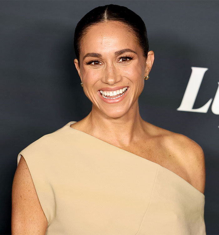 Woman in an elegant beige dress smiling on a red carpet, discussed for her kids' parties advice. Woman in an elegant beige dress smiling on a red carpet, discussed for her kids' parties advice.