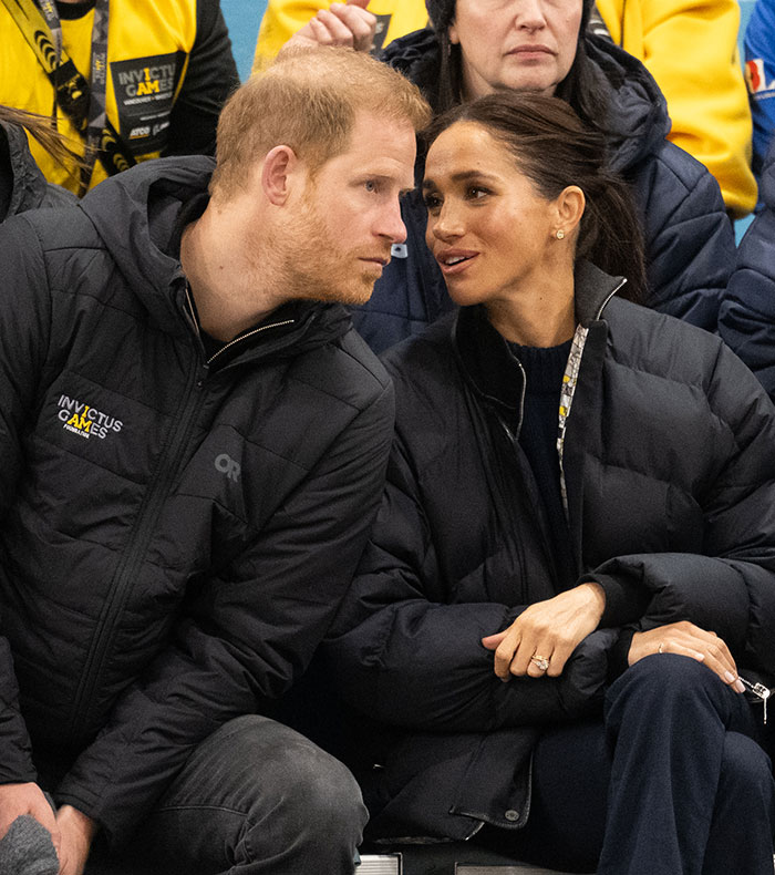 A couple seated, wearing black jackets at an event, engaging in a conversation. Hollywood is abuzz over Meghan Markle. A couple seated, wearing black jackets at an event, engaging in a conversation. Hollywood is abuzz over Meghan Markle.