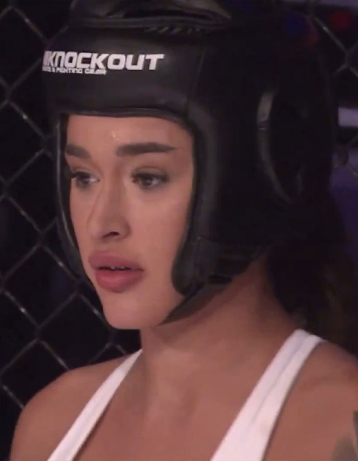 MMA fighter wearing protective gear in a controversial fight setting. MMA fighter wearing protective gear in a controversial fight setting.