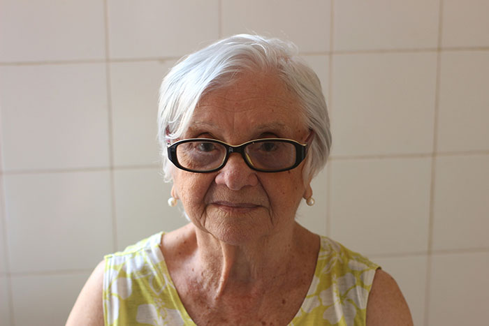 Elderly woman with glasses and a patterned blouse, related to a story about a mother-in-law offended over sleeping arrangements. Elderly woman with glasses and a patterned blouse, related to a story about a mother-in-law offended over sleeping arrangements.