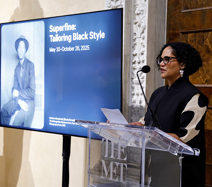 A woman speaks at a Met event, highlighting the 2025 dress code and the "Superfine: Tailoring Black Style" exhibit. A woman speaks at a Met event, highlighting the 2025 dress code and the "Superfine: Tailoring Black Style" exhibit.