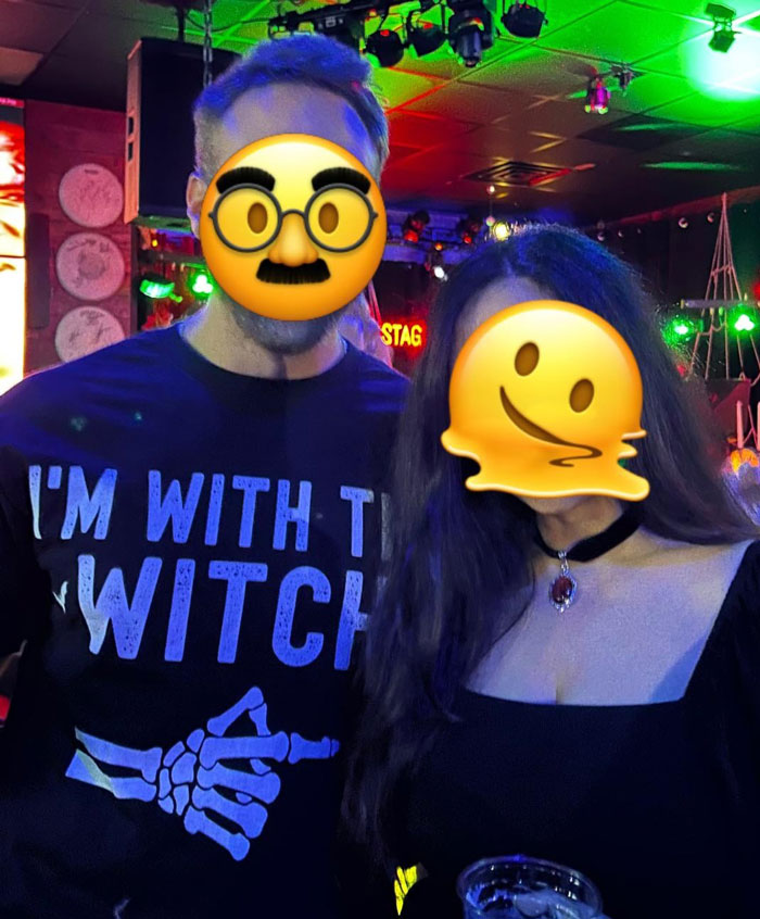 Couple in Halloween attire, with one wearing a "Witch" themed shirt at a festive party. Couple in Halloween attire, with one wearing a "Witch" themed shirt at a festive party.