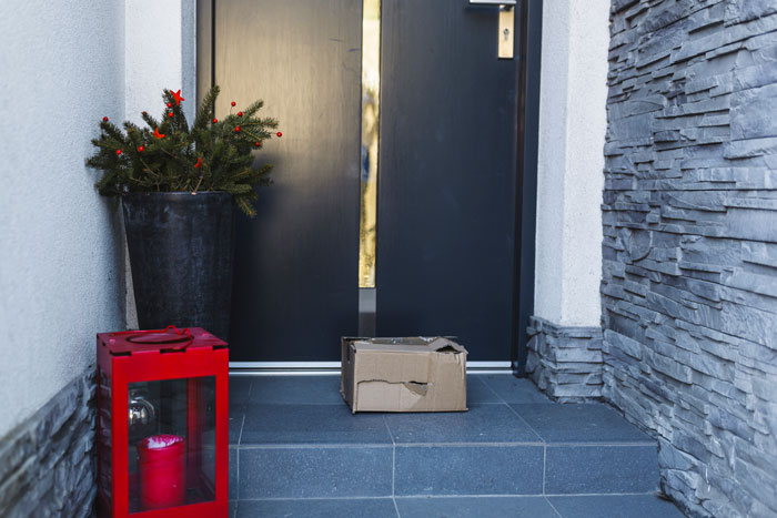 Package left on doorstep with a potted plant and red lantern, illustrating neighborhood delivery issue. Package left on doorstep with a potted plant and red lantern, illustrating neighborhood delivery issue.
