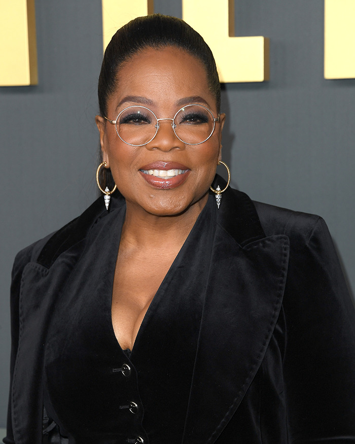 Oprah wearing glasses and a black outfit at an event. Oprah wearing glasses and a black outfit at an event.