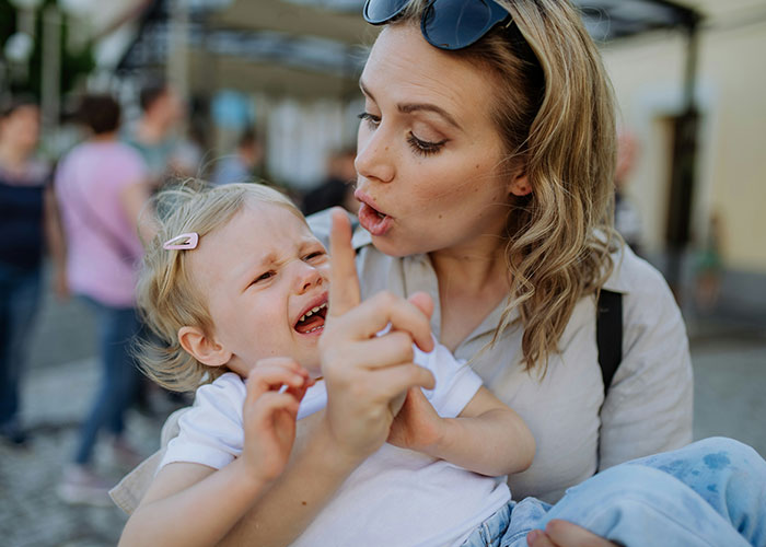 Parenting coach explaining to upset child while pointing a finger, emphasizing calm communication over yelling. Parenting coach explaining to upset child while pointing a finger, emphasizing calm communication over yelling.