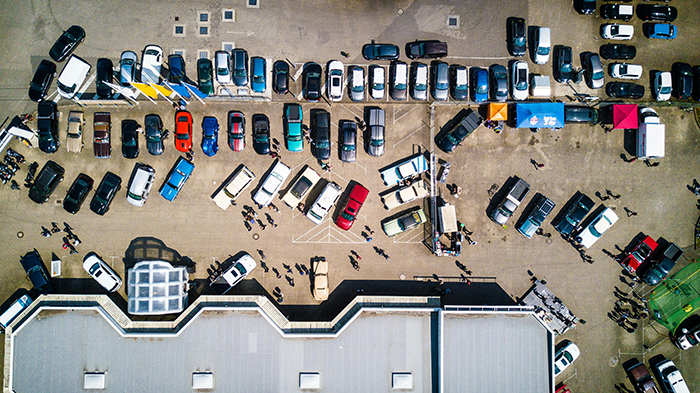 Aerial view of a crowded parking lot with cars parked haphazardly, illustrating parking disputes and issues. Aerial view of a crowded parking lot with cars parked haphazardly, illustrating parking disputes and issues.