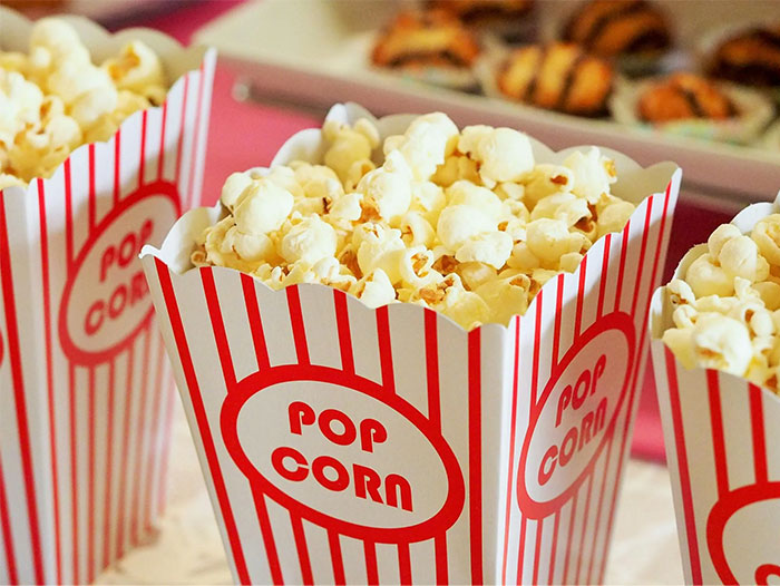 Popcorn in red-striped boxes at a counter, related to "pay it forward" discussion. Popcorn in red-striped boxes at a counter, related to "pay it forward" discussion.