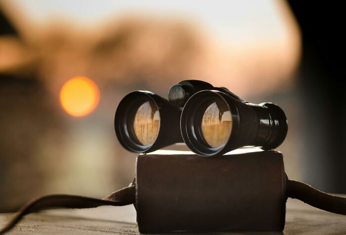 Binoculars resting on a case at sunset, perfect for wordless trivia questions on visual thinking abilities. Binoculars resting on a case at sunset, perfect for wordless trivia questions on visual thinking abilities.