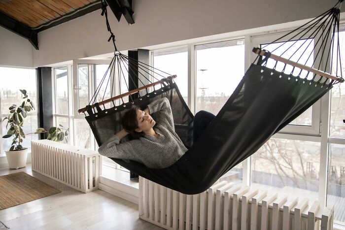 Person relaxing in a hammock by a window, illustrating human genetic blessings and weaknesses in a peaceful environment.