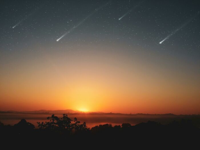 Shooting stars over a sunset, connected to superstitions about wishes coming true.