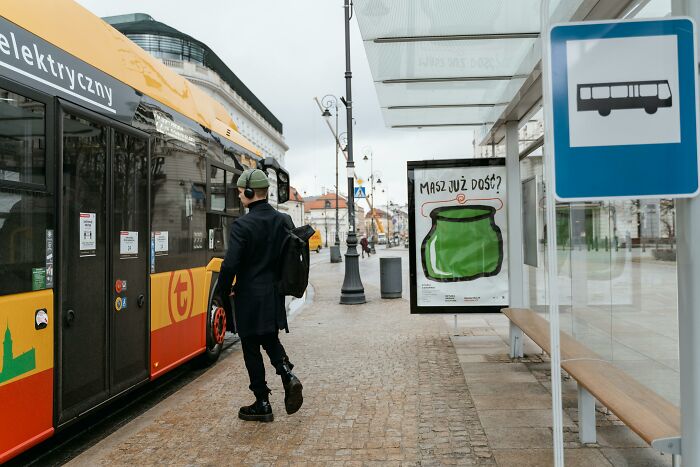 Person boarding a colorful city bus at a bus stop, illustrating public transport social rules people often ignore.