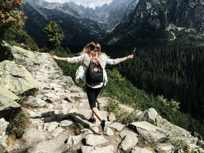Woman hiking on a mountain trail, enjoying the freedom of a childfree lifestyle.