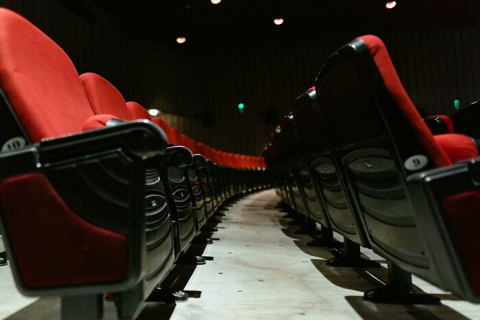 Empty theater seats highlighting social rules people ignore about public space etiquette.