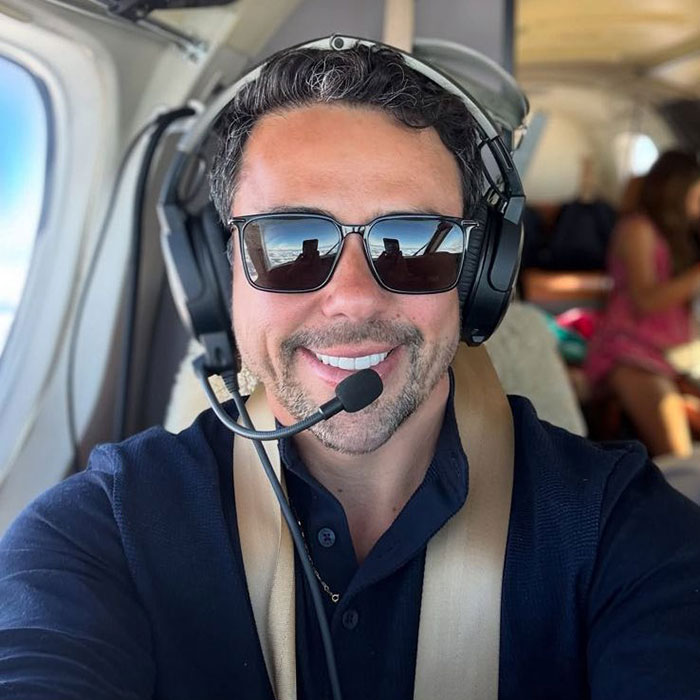 Pilot in cockpit smiling, wearing sunglasses and headset, involved in the latest aviation disaster. Pilot in cockpit smiling, wearing sunglasses and headset, involved in the latest aviation disaster.