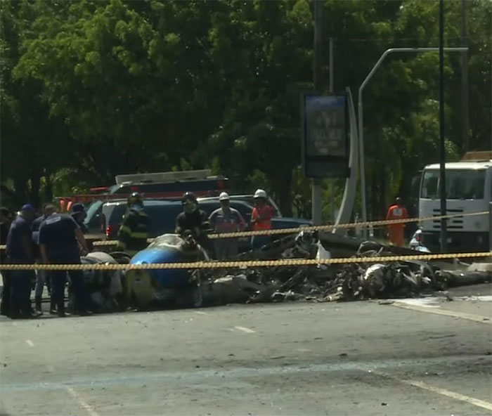 Aviation disaster scene with plane wreckage and emergency responders behind caution tape. Aviation disaster scene with plane wreckage and emergency responders behind caution tape.
