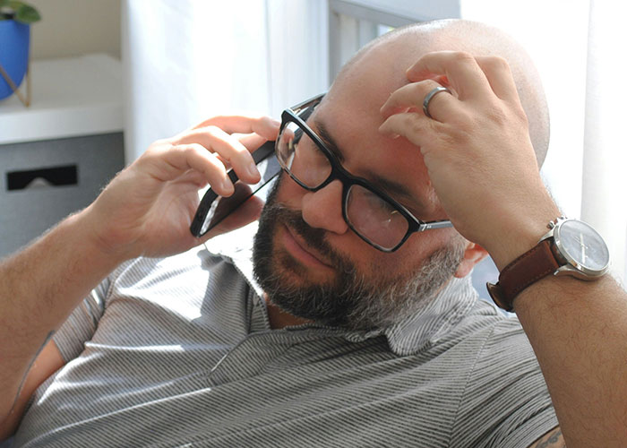 Man in glasses on a phone call, looking stressed, possibly discussing family BBQ and stepsiblings issue. Man in glasses on a phone call, looking stressed, possibly discussing family BBQ and stepsiblings issue.