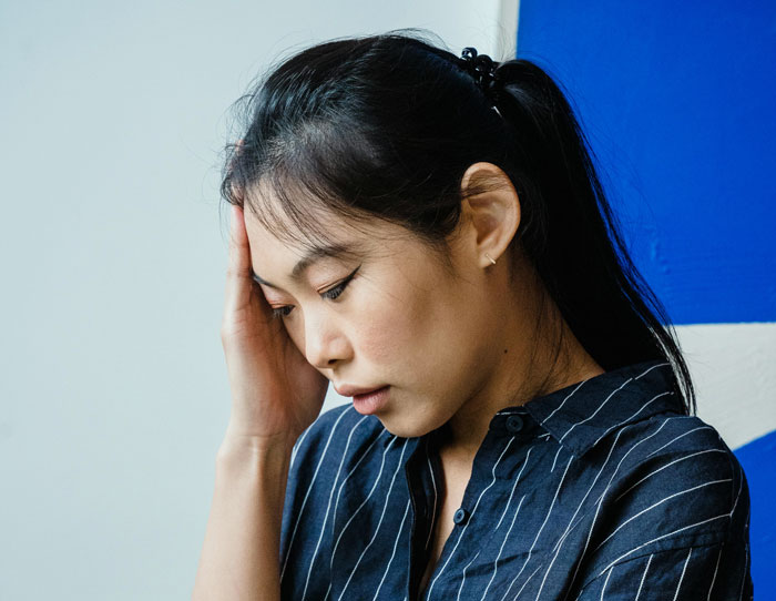 29YO woman looking stressed, in a striped shirt, pondering family expectations, related to babysitting nephews. 29YO woman looking stressed, in a striped shirt, pondering family expectations, related to babysitting nephews.