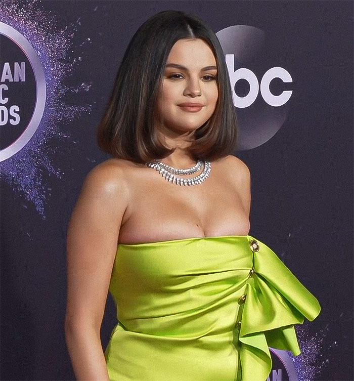 Selena Gomez in a neon green dress at the awards show, showcasing a dramatic weight loss transformation. Selena Gomez in a neon green dress at the awards show, showcasing a dramatic weight loss transformation.