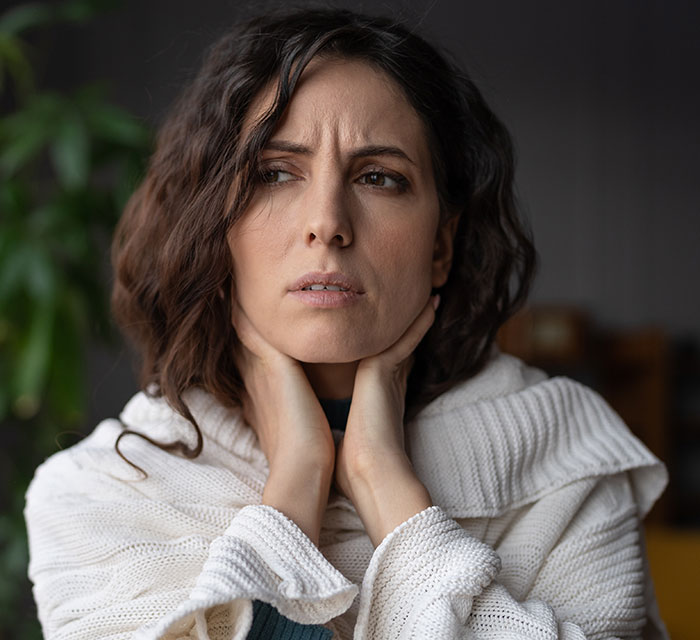 A concerned parent in a white sweater, reflecting on unexpected party guests. A concerned parent in a white sweater, reflecting on unexpected party guests.