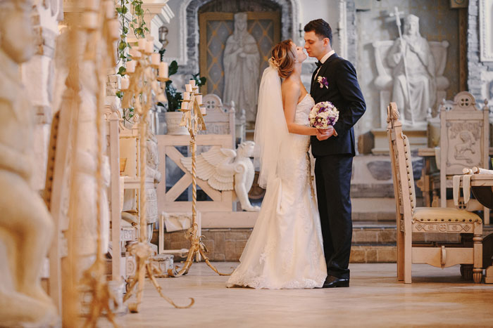 Bride and groom kissing in an ornate wedding venue, symbolizing family choices and wedding dynamics. Bride and groom kissing in an ornate wedding venue, symbolizing family choices and wedding dynamics.