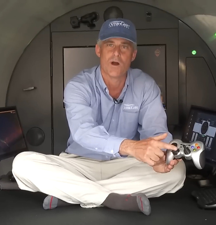 Stockton Rush in a cap sitting with a game controller. Stockton Rush in a cap sitting with a game controller.