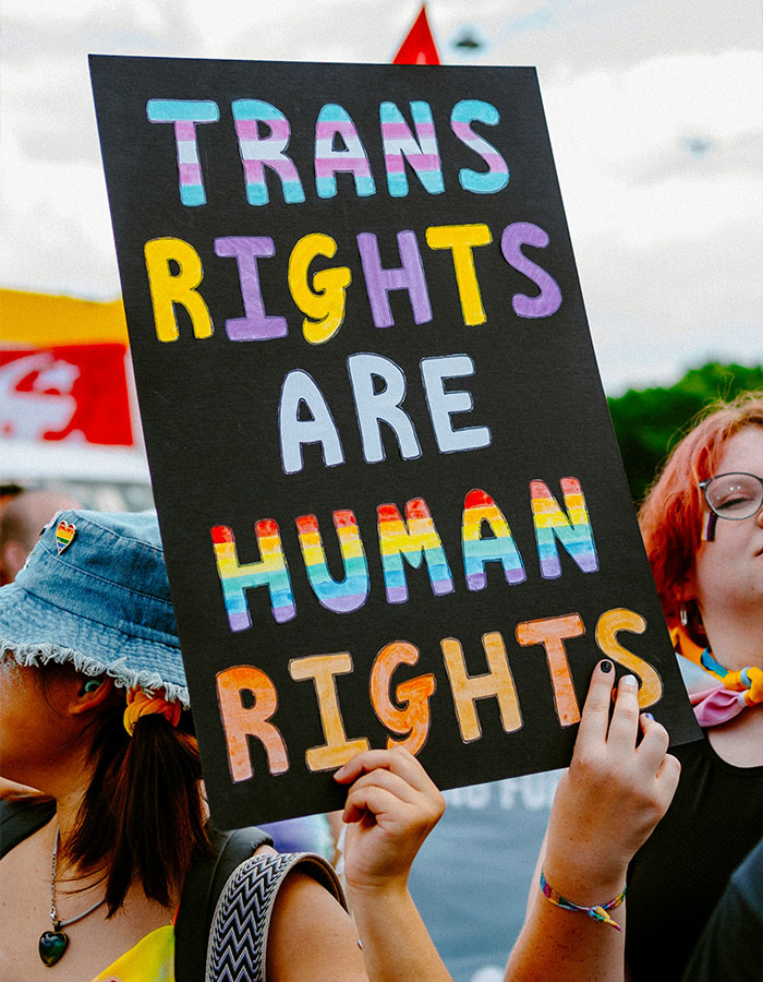 Person holding a sign saying "Trans rights are human rights" at a rally for transgender inclusion in sports. Person holding a sign saying "Trans rights are human rights" at a rally for transgender inclusion in sports.