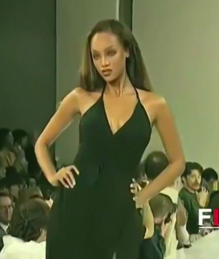 A model in a black dress walking down the runway, capturing attention with her confident expression. A model in a black dress walking down the runway, capturing attention with her confident expression.