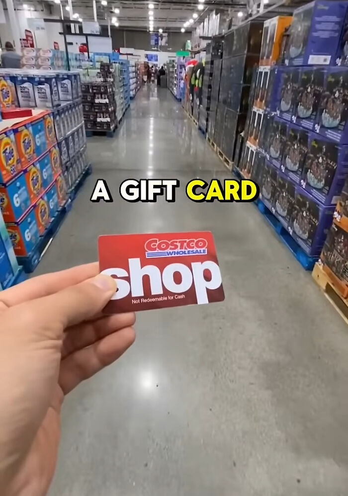 Hand holding a Costco gift card inside a store aisle, representing shopping hacks. Hand holding a Costco gift card inside a store aisle, representing shopping hacks.