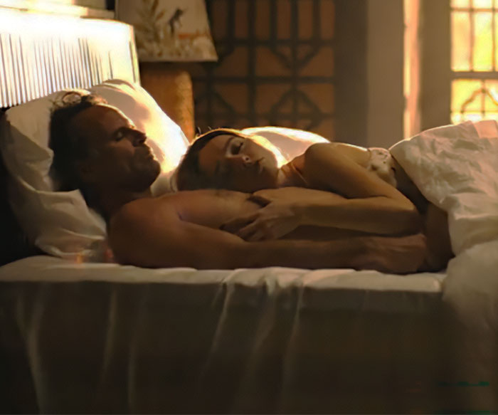 Couple lying in bed during an intimate scene, evoking discussion on intimacy coordinators in film. Couple lying in bed during an intimate scene, evoking discussion on intimacy coordinators in film.
