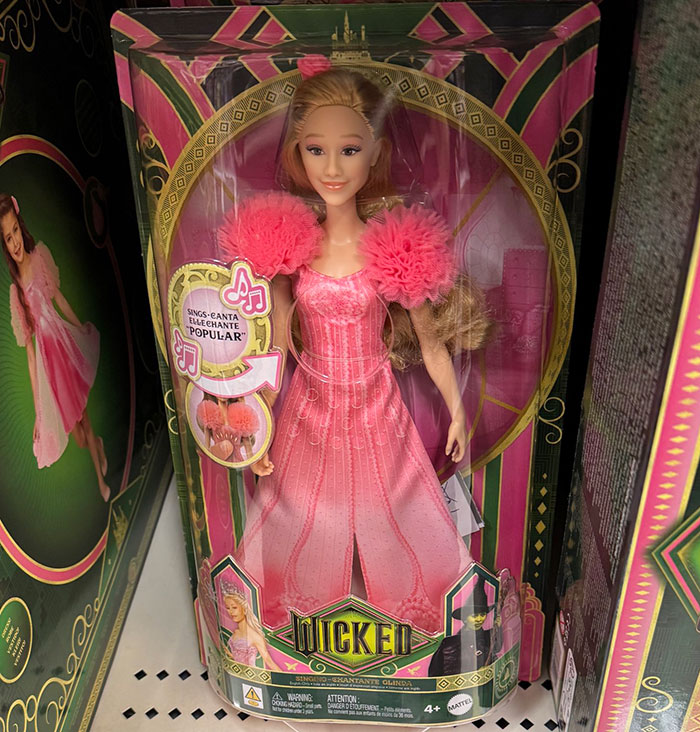 Kids' toy doll in pink dress with "Wicked" branding. Kids' toy doll in pink dress with "Wicked" branding.